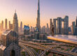 Un homme d'affaires regarde le panorama urbain de Dubaï au coucher du soleil depuis une plateforme surplombant la ville.
