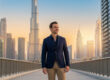 Un entrepreneur en costume devant la skyline de Dubaï au coucher du soleil.