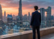 Un homme d'affaires regarde les gratte-ciel de Dubaï avec des graphiques financiers numériques en surimpression.