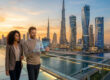 Un homme et une femme d'affaires regardent des données financières sur une tablette numérique devant la skyline de Dubaï.