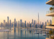 Vue panoramique sur les gratte-ciel de Dubaï et le port de plaisance au crépuscule depuis un balcon moderne.